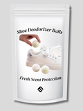 Set of 12 white shoe deodorizer balls with ventilation holes placed near suede ankle boots on a wooden surface