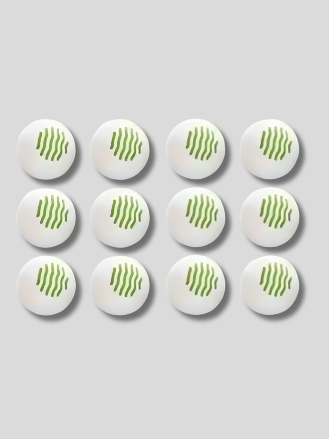 Set of 12 white shoe deodorizer balls with ventilation holes placed near suede ankle boots on a wooden surface