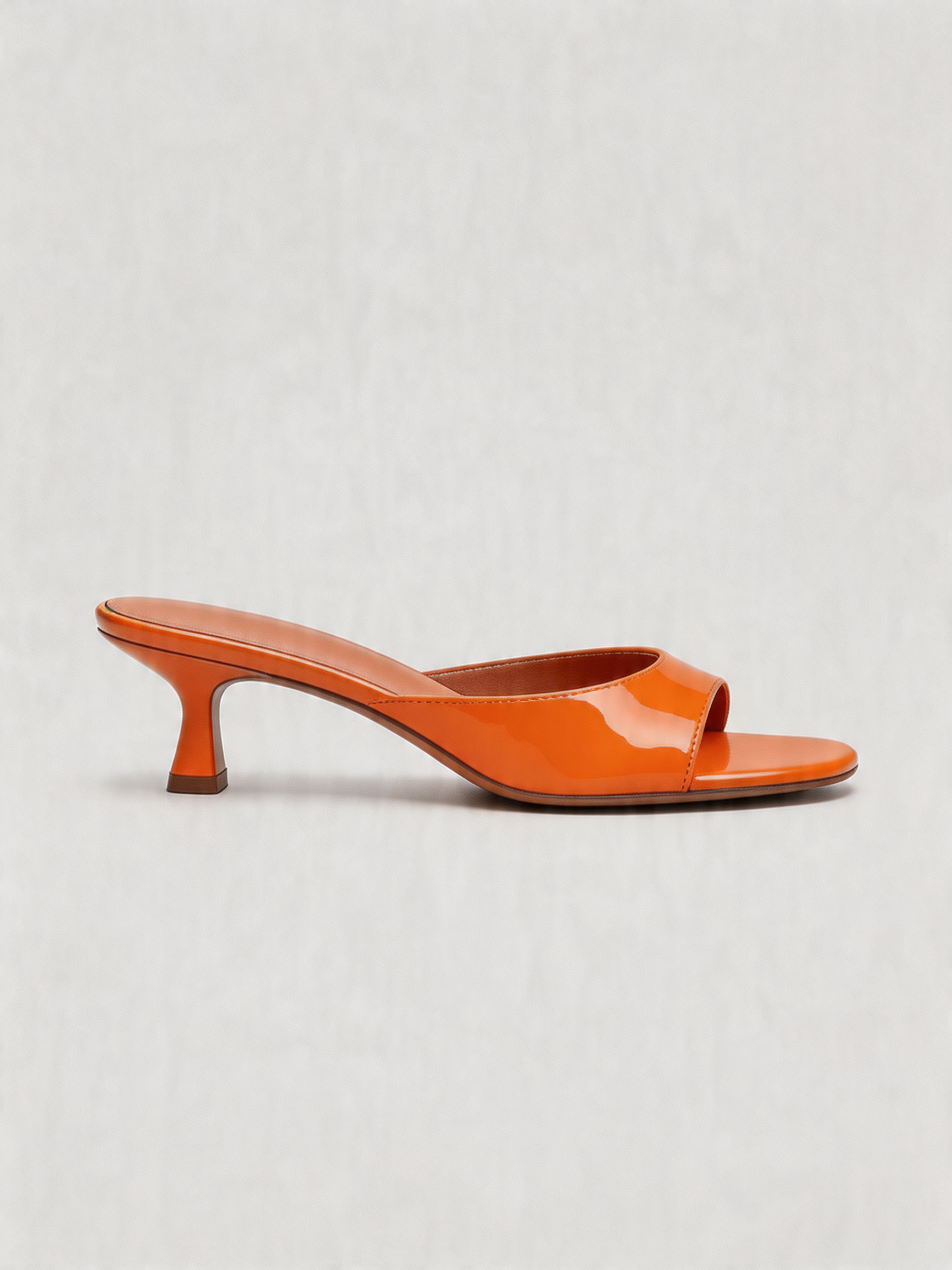 Patent curved heel mule square open toe tangerine orange top view women's
Patent curved heel mule square open toe tangerine orange side view women's
Patent curved heel mule square open toe tangerine orange heel detail women's
